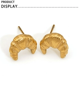 Detailed view of golden croissant horn stud earrings on a clean white background