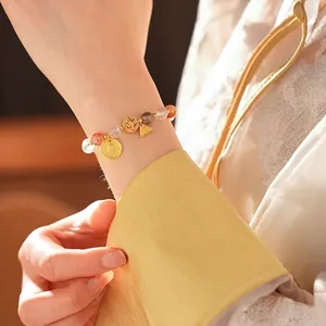 Colorful crystal moonstone bracelet with Fu character pendant and gold accents on wrist