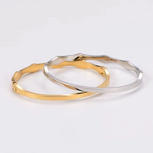 Detail view of gold and silver bamboo-style stainless steel bracelets with snap closure