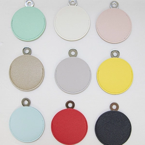 Set of 9 colorful round PU leather pocket mirrors with metal rings on plain background