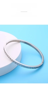 Detailed macro view of diamond-encrusted silver titanium steel bangle with rhombus pattern