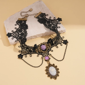 Detail eines gotischen schwarzen Spitzen-Chokers mit lila Blumen und Cameo-Anhänger