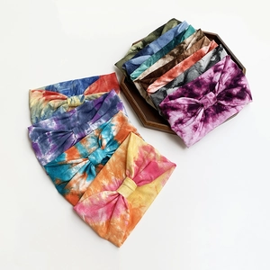 Tie-dye wide elastic yoga headbands for women displayed in various colors on wooden tray