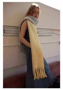 Detail of wool blend gradient scarf in yellow and blue featuring soft fringe tassels