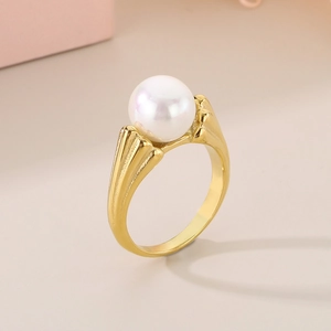 Dettaglio macro di una grande perla bianca su un elegante anello placcato oro 18K