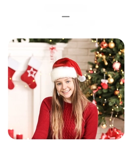 Close-up of plush red Santa hat with white faux fur trim against Christmas lights