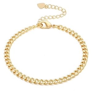 Detail of golden curb chain bracelet featuring a lobster clasp and heart charm extender
