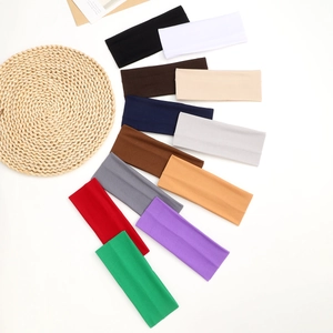 Flat lay of wide elastic sports headbands in 12 various colors displayed in a fan arrangement