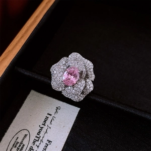 Macro shot of camellia flower ring with pink oval zircon and silver petals