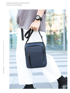 Dettaglio della borsa a tracolla in nylon blu scuro impermeabile con cerniera verticale