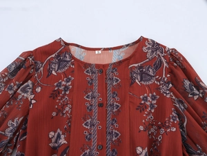Detailed view of round neckline on vintage floral print dress with black buttons and pleated shoulders