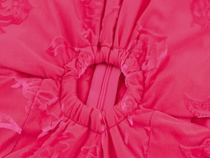 Détail de la robe à étages rose rouge montrant la fermeture éclair invisible et le jacquard