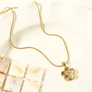 Golden eye flower necklace set with colorful gems on elegant white ceramic display