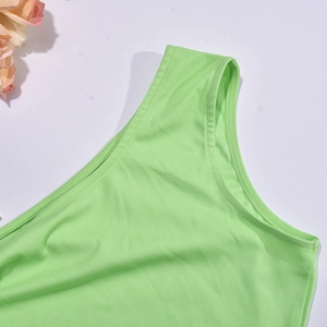 Détail d'une robe asymétrique vert vif montrant des coutures de qualité et texture côtelée