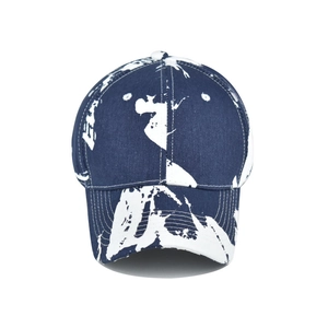 Detail of navy blue tie-dye baseball cap featuring white abstract splatter patterns