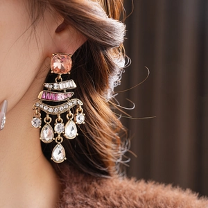 Close-up of vintage earrings with colorful rhinestones and water drop fringe on a model