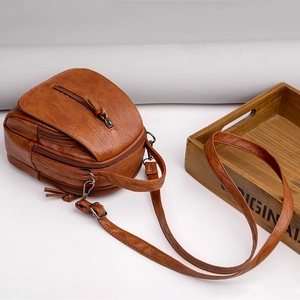 Brown faux leather crossbody bag with multiple zip pockets and adjustable strap