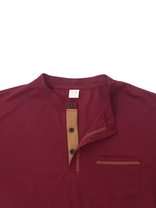 Détail du col tunisien bordeaux avec boutons et texture du tissu sur polo manches longues