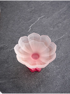Top-down view of pink frosted glass tea cup with elegant petal-shaped rim and base