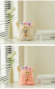 Detail view of pink and white plush Highland cows with floral crowns and golden bells