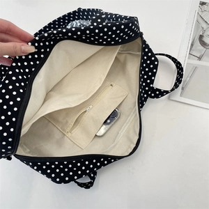 Close-up of the spacious main compartment with a zipper pocket inside a polka dot tote bag