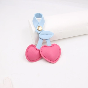 Detail of pink heart-shaped cherry charms with light blue leather leaves and gold clasp