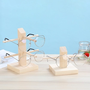 Minimalist pine wood eyewear display stand in two sizes on a light wooden tabletop