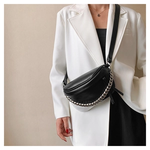 Detail of black semi-circular leather chest bag with a thick silver metal chain and strap