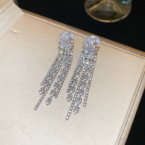 Macro detail of long silver zircon tassel earrings elegantly displayed in a premium jewelry box