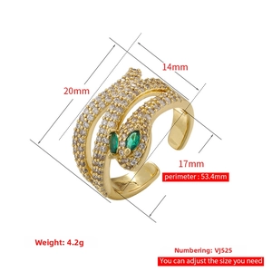 Detail view of adjustable gold snake ring with green gem eyes and white crystal inlay