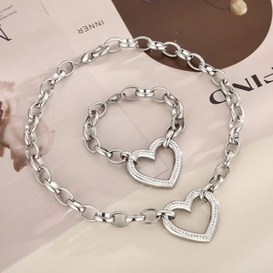 Macro shot of silver chunky chain necklace and bracelet set with crystal heart pendants