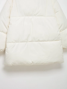 Gros plan d'une doudoune blanc cassé montrant les détails des coutures et du tissu
