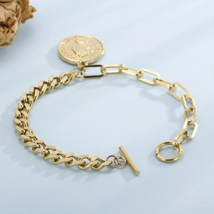 Bracelet vintage avec pendentif pièce d'or et fermoir à bascule OT sur fond bleu