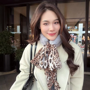 Detailed shot of grey faux fur neck warmer with leopard print silk ribbon accent