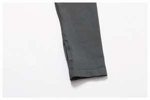 Détail macro du poignet d'une veste de yoga gris foncé avec trou pour le pouce et coutures