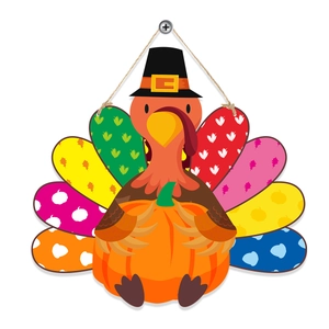Macro shot of colorful wooden turkey door hanger with pumpkin and autumn leaf details