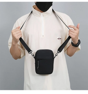 Men's casual black nylon crossbody bag shown on model with adjustable strap