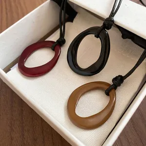 Pendentifs géométriques ovales en rouge, noir et ocre avec cordon noir élégant