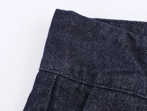 Makro-Detail von dunkelblauem Denim-Stoff mit Köperstruktur und Faltennaht-Details