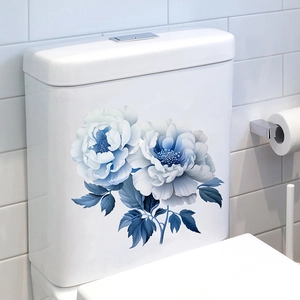 Dettaglio adesivo floreale con peonia blu su un serbatoio per WC in ceramica bianca