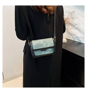 Detail view of the vintage teal crossbody bag texture and black leather piping