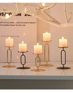 Detailed view of modern black and gold metal candle holders with white pillar candles