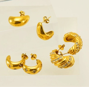 Detailed view of three pairs of 18k gold plated hoop earrings with zircons and textures