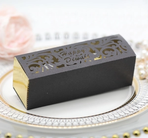 Makro-Detail der lasergeschnittenen Diwali-Geschenkbox in Gold und Schwarz auf Dekoteller