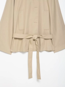 Detail view of khaki trench coat featuring waist tie belt and vertical side pockets