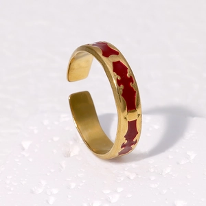 Detailed side view of vintage gold ring with red enamel inlay on white stone