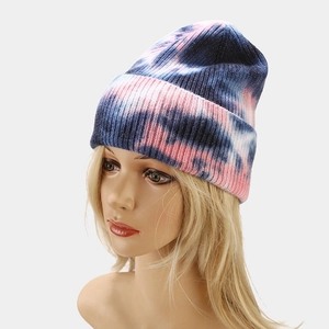Close-up of pink and blue tie-dye knit beanie showing yarn texture and rolled edge detail