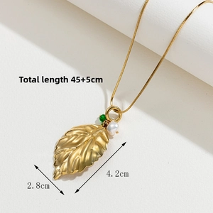 Détail du collier feuille d'or avec une perle blanche et un pendentif vert