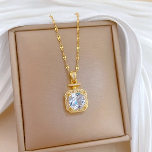 Détail du pendentif flacon de parfum doré avec cristaux dans une boîte à bijoux