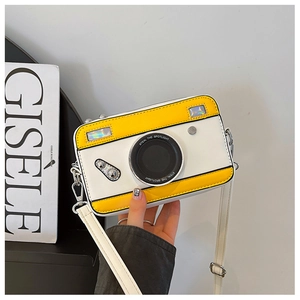 Detail of camera-shaped crossbody bag with yellow and white color block leather design